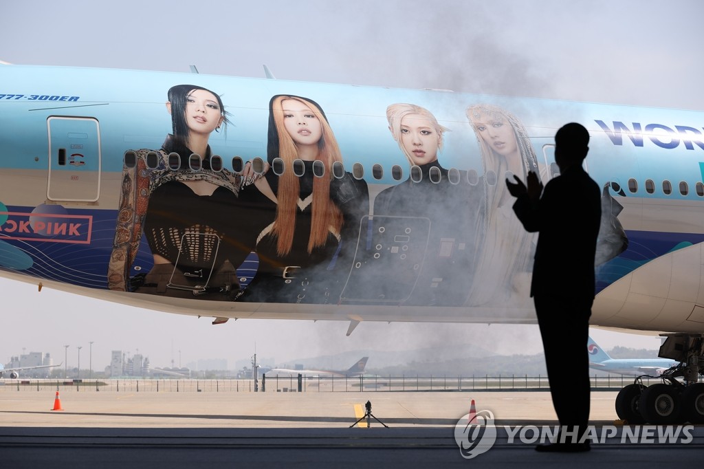Prime Minister Han Duck-soo applauds at a hangar of Korean Air Co. at Incheon airport, west of Seoul, on May 3, 2023, during an event to unveil a plane carrying an image of South Korean girl group BLACKPINK as part of the private sector's publicity efforts to wish for the country's successful bid to host the 2030 World Expo in the southeastern port city of Busan. (Yonhap)