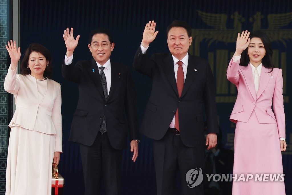 South Korean President Yoon Suk Yeol (2nd from R) and his wife, Kim Keon Hee (R), wave with Japanese Prime Minister Fumio Kishida (2nd from L) and his wife, Yuko, during a welcome ceremony for the Japanese leader at the presidential office in Seoul on May 7, 2023. (Yonhap)