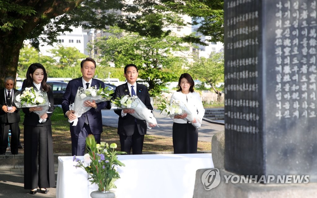 South Korean President Yoon Suk Yeol (2nd from L), Japanese Prime Minister Fumio Kishida (2nd from R), first lady Kim Keon Hee (L) and Kishida's wife, Yuko, pay tribute in front of a cenotaph for Korean victims of the atomic bombing of Hiroshima at the Peace Memorial Park in Hiroshima, Japan, on May 21, 2023. (Yonhap)