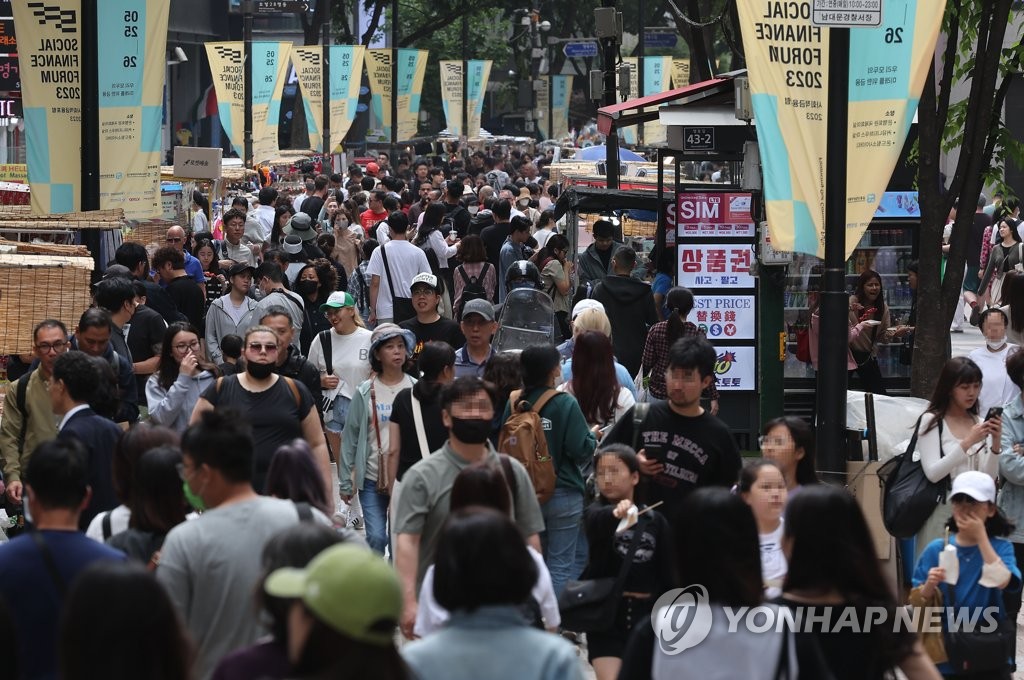 This photo, taken May 21, 2023, shows a street packed with people in the popular tourist district of Myeongdong in central Seoul. (Yonhap)