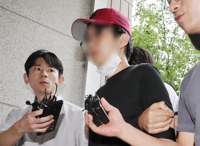 여객기 비상문 개방 시도 10대…법원 출석 중 얼굴 공개