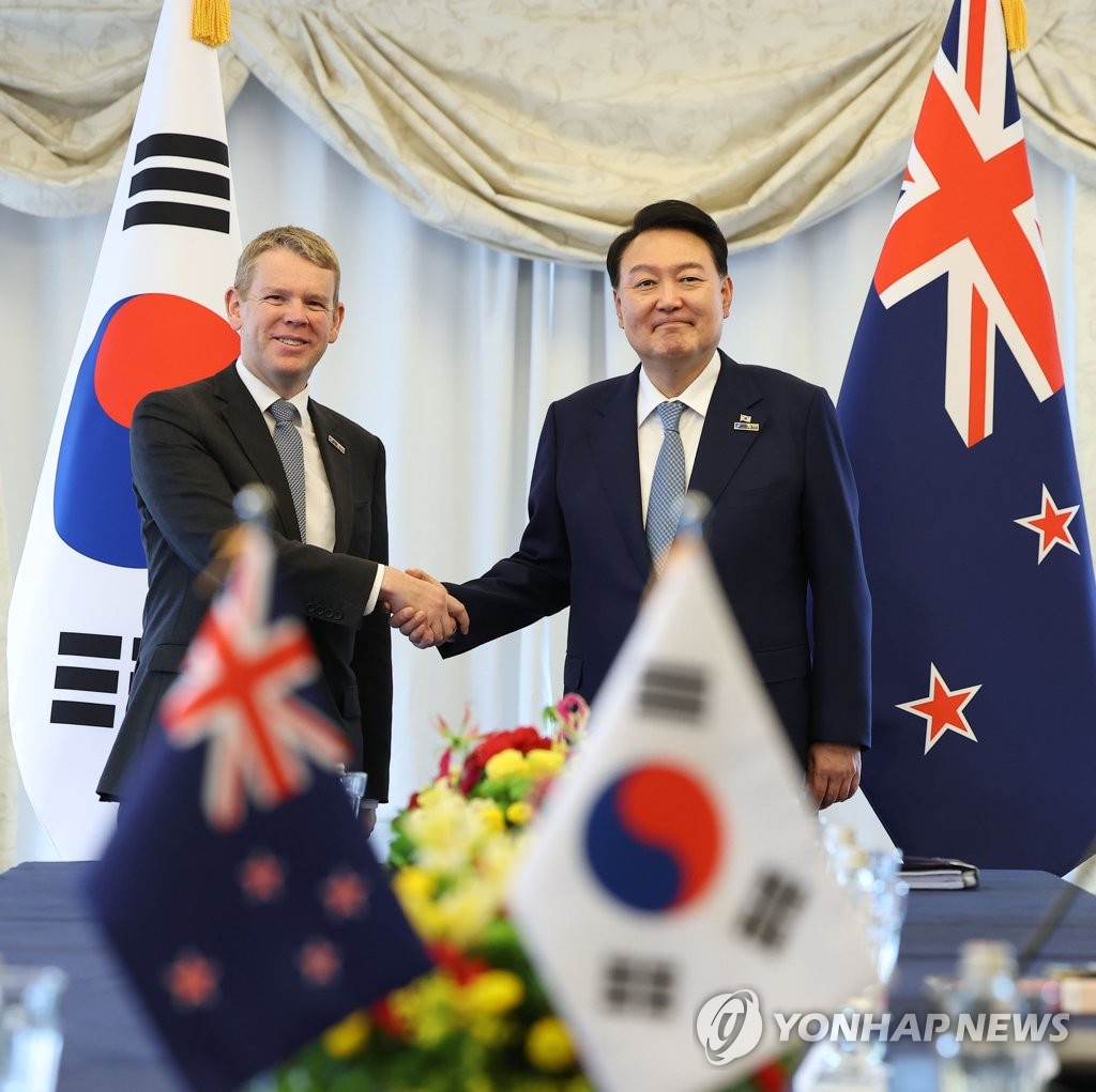 El presidente de Corea del Sur, Yoon Suk Yeol (derecha), le da la mano al primer ministro de Nueva Zelanda, Chris Hipkins, durante sus conversaciones en Vilnius, Lituania, el 11 de julio de 2023, al margen de una cumbre de dos días de la Organización del Tratado del Atlántico Norte.  (Yonhap)