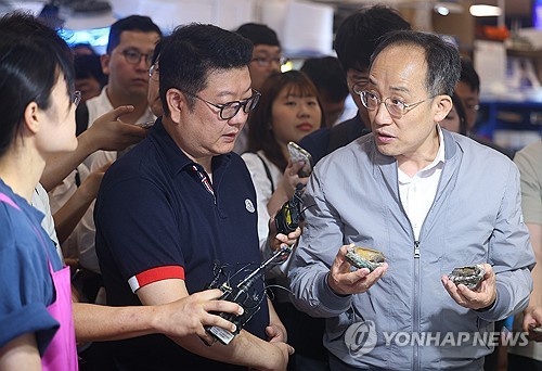 Finance Minister Choo Kyung-ho (R) speaks to a shop owner at a fish market in Seoul on Sept. 20, 2023. (Yonhap)