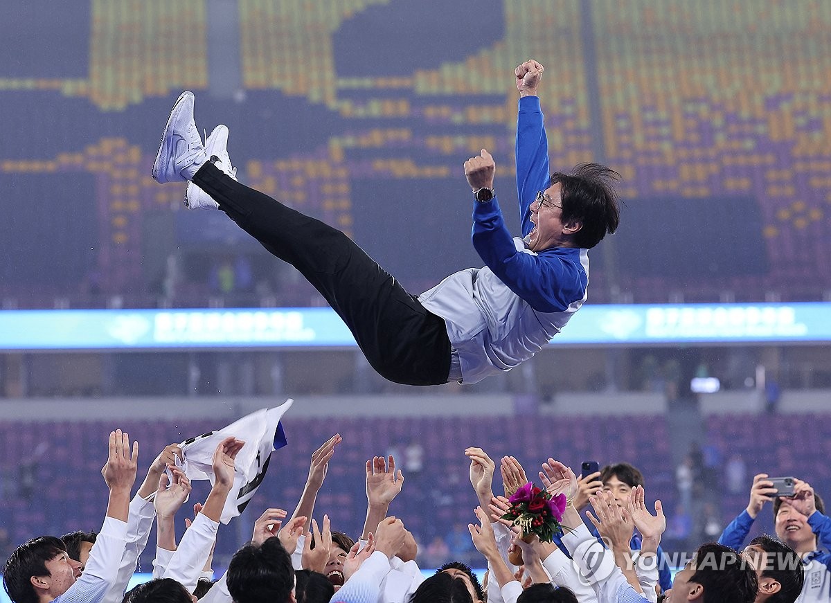 2023년 10월 7일 촬영된 이 파일 사진에서 한국 선수들이 중국 항저우 황룡체육관에서 열린 아시안게임 남자 축구 금메달을 놓고 일본을 2-1로 꺾은 뒤 황선홍 감독을 공중으로 던지고 있다.  (연합)