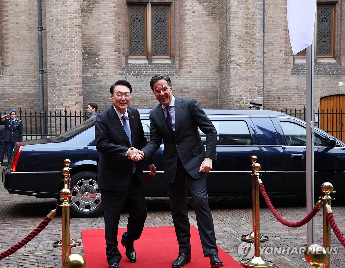 El presidente Yoon Suk Yeol (izq.) estrecha la mano del primer ministro holandés, Mark Rutte, cuando llega a la oficina de Rutte en La Haya para su cumbre el 13 de diciembre de 2023. (Yonhap)