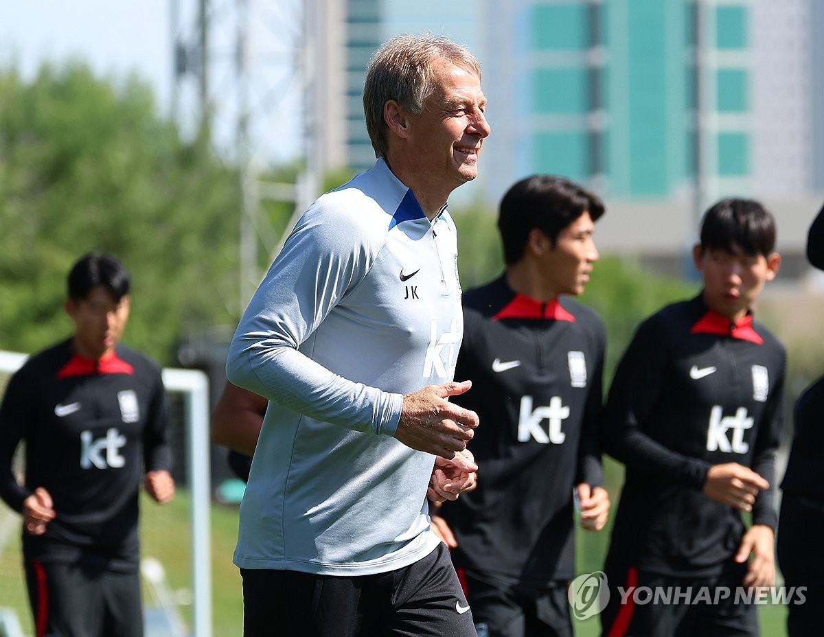 South Korea head coach Jurgen Klinsmann jogs alongside his players during a training session at Al Egla Training Site in Doha on Feb. 3, 2024, ahead of the semifinal match against Jordan at the Asian Football Confederation Asian Cup. (Yonhap)