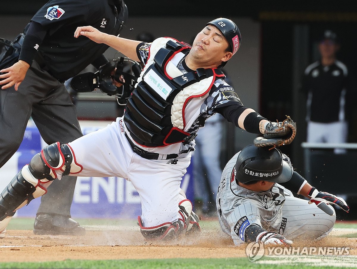 Choi Jae-hoon of the Hanwha Eagles (R) beats the tag by KT Wiz catcher Jang Sung-woo to score during the teams' Korea Baseball Organization regular-season game at KT Wiz Park in Suwon, 30 kilometers south of Seoul, on June 4, 2024. (Yonhap)