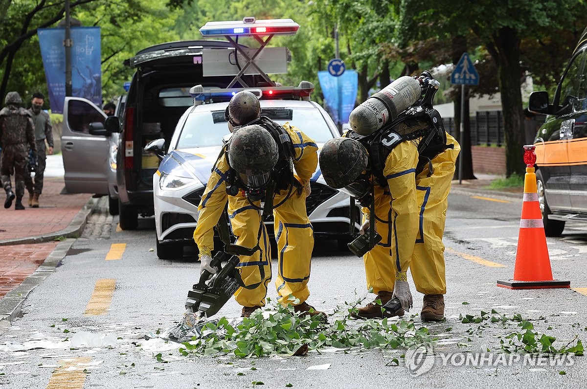 Oficiales militares recogen el contenido de un globo que transportaba basura lanzado por Corea del Norte y que cayó en el centro de Seúl el 24 de julio de 2024. (Yonhap)