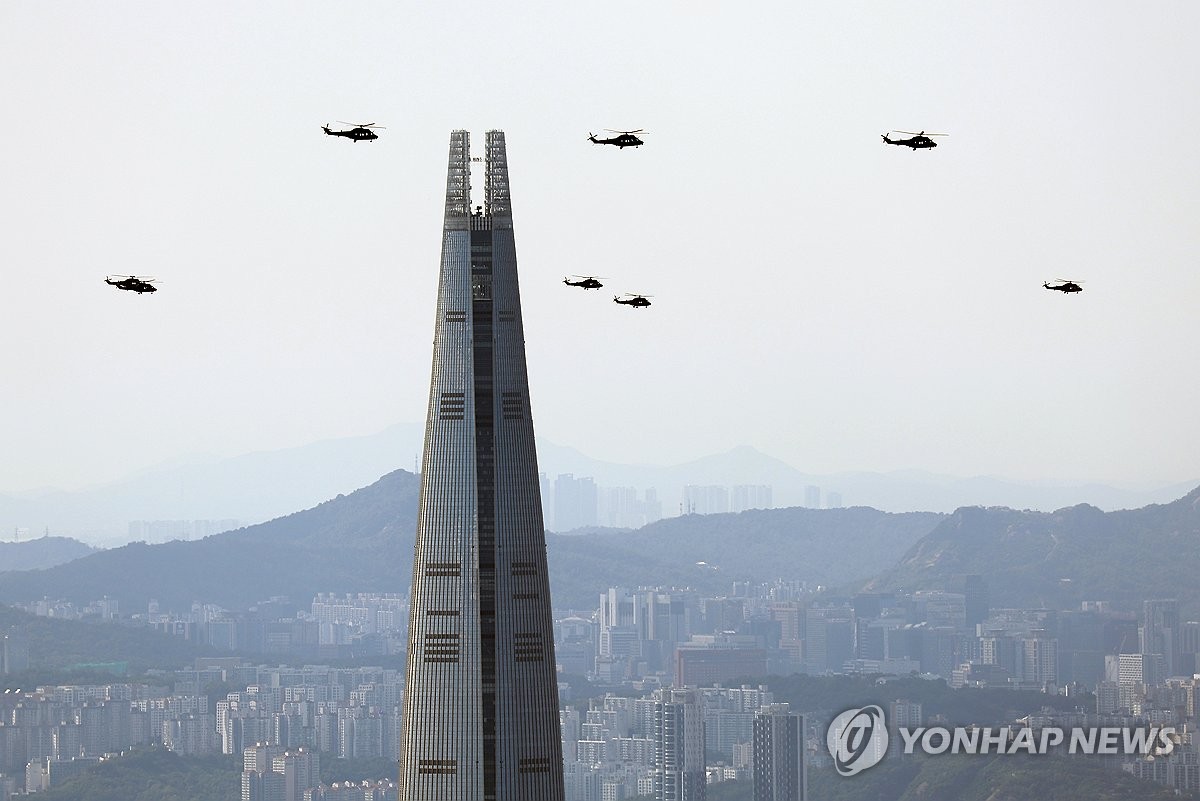 超高層ビルを通り過ぎる陸軍ヘリ