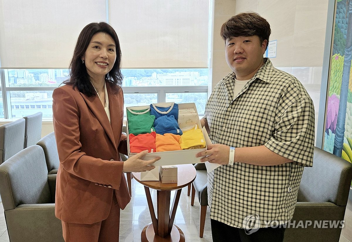 You Hye-mi (izq.), secretaria presidencial de alto rango para asuntos de baja tasa de natalidad, entrega un regalo de felicitación del presidente Yoon Suk Yeol a Kim Jun-young (der.), padre de quintillizos recién nacidos, en un hospital de Seúl el 22 de septiembre de 2024, en esta foto proporcionada por la oficina presidencial. (FOTO NO A LA VENTA) (Yonhap) 