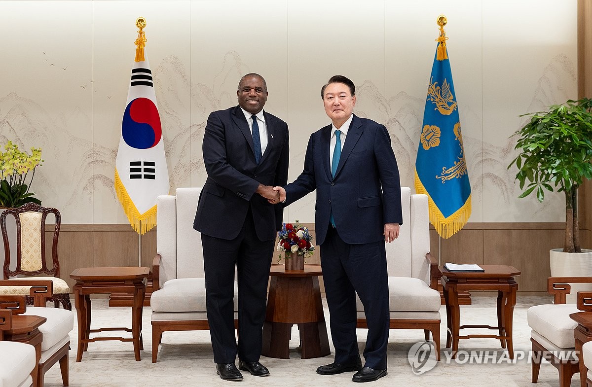 El presidente Yoon Suk Yeol (derecha) posa con el secretario de Asuntos Exteriores británico, David Lammy, durante su reunión en la oficina presidencial en Seúl, el 21 de octubre de 2024, en esta fotografía proporcionada por la oficina de Yoon. (FOTO NO EN VENTA) (Yonhap)