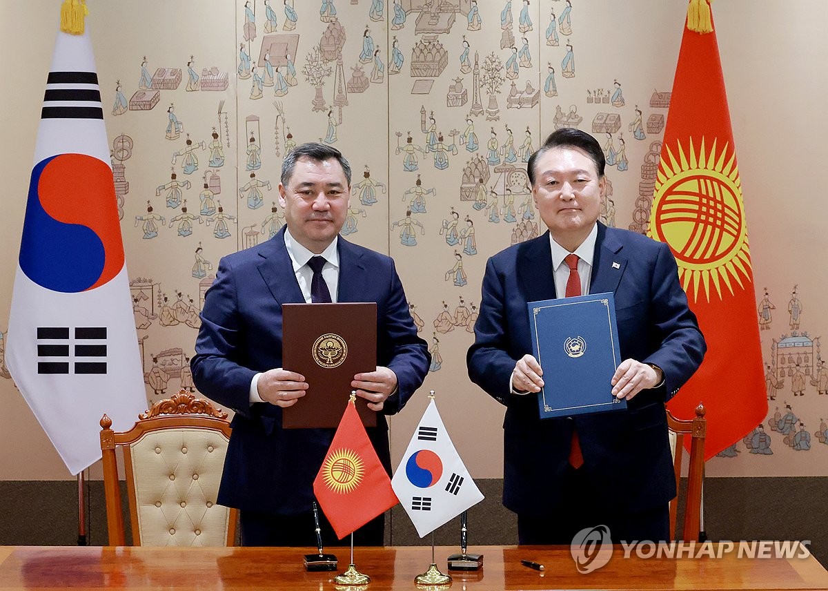 South Korean President Yoon Suk Yeol (R) and Kyrgyz President Sadyr Japarov pose after signing a joint statement on the establishment of a comprehensive strategic partnership at the presidential office in Seoul on Dec. 3, 2024. (Yonhap)